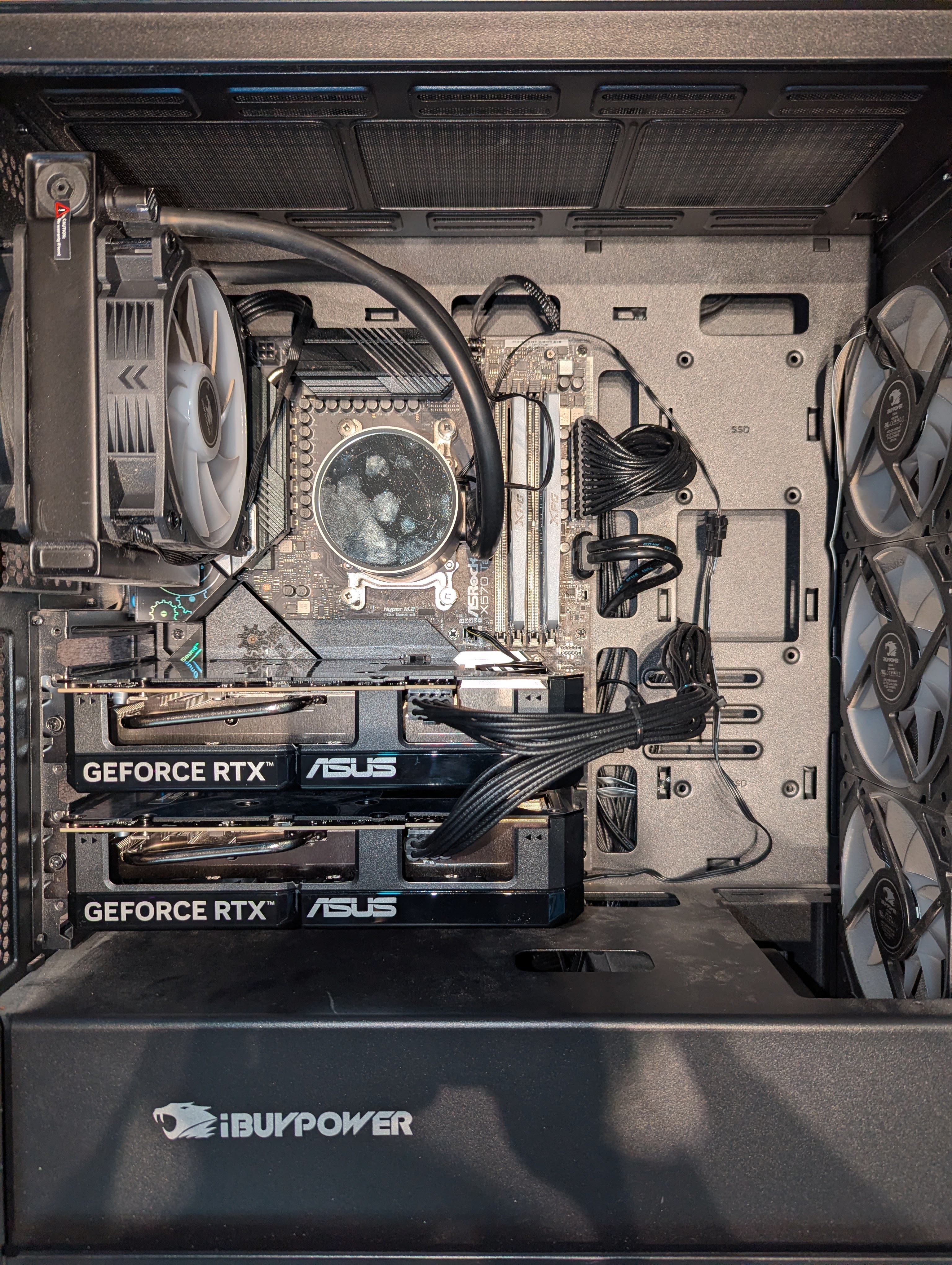 adi-cortex interior — dual ASUS RTX 5060 Ti cards mounted in PCIE1 and PCIE2 of an ASRock X570 Taichi inside an iBUYPOWER chassis with 240mm AIO cooling the Ryzen 5 5600X